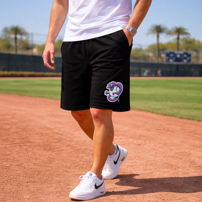 Person wearing black shorts with a logo on a baseball field